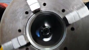 Yuvarlak metal parçaları öğütme makinesinin içinde dönüyor, derrick ekipmanları üretiyor, yakın plan. Endüstri fabrikasında faaliyet gösteren teknoloji üreticisi. 4k video