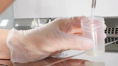 Sperm örneğiyle çalışan doktorların yakın çekimi. Analiz için test bankasından sperm çıkaran bilim adamı embriyolog. Modern mikrobiyoloji dolabında laboratuvar çalışanı. 4k video