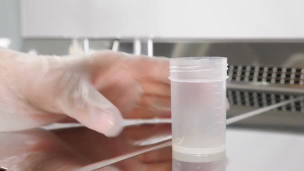 现代微生物学橱柜的实验室工作人员。检查精液样本的医生的特写。科学家胚胎学家将精子从试验库中取出进行分析。4k视频 — 图库视频影像