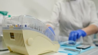Sağlık sigortası konsepti. Modern diş muayenehanesinde diş sondajı için limanı seçen ve alan dişçi, yakın görüş. Diş aletleri için steril matkap. Steril diş aletlerini çıkarıyorum. 4