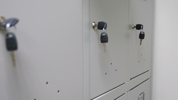 Pequeños casilleros de seguridad con llaves. Llave de primer plano en las cerraduras en el vestuario del gimnasio o sala de personal. concepto de caja de seguridad de seguridad de metal. 4 k imágenes — Vídeos de Stock