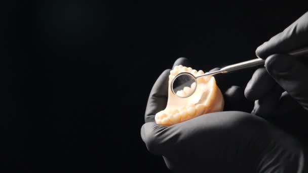 在牙科诊所的黑色背景上拍摄的牙龈旋转机械手的近景，牙冠抛光边缘的慢动作。全hd — 图库视频影像