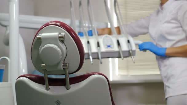 Tandläkarverktyg som rengörs av kvinnlig assistent på modern tandvårdsklinik. Förbereder tandläkarmottagningen före patienterna. Rengörings- och desinfektionsövningar inom tandvården. Sterilisering och desinficering. 4 k — Stockvideo