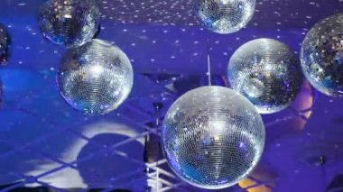 Parlak ışınlı disko topu, mavi arka planlı gece partisi. Gece kulübünde bir sürü gösterişli renkle parti dans salonu kutlaması. Dönen disko ayna topu. 4k video