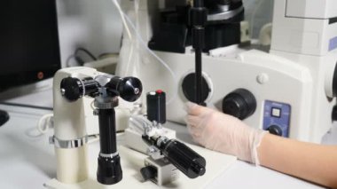 Modern tıp laboratuarında üreme tıbbı. Doğurganlık uzmanı icsi ivf prosedürü uygularken joystick 'i mikro manipülatör iğnelerini ayarlamak için hareket ettiriyor. Suni döllenme. 4k video