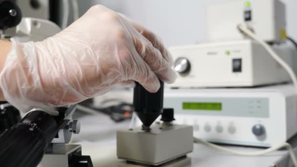 Kunstmatige inseminatie in wetenschappelijk laboratorium onder microscoop. Vruchtbaarheid specialist uitvoeren van icsi ivf procedure bewegende joystick om micromanipulator naalden aan te passen. 4 k video — Stockvideo