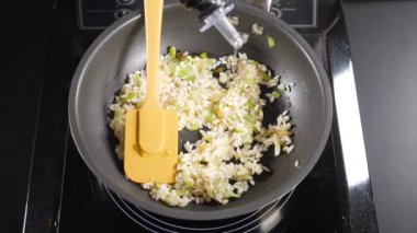 Restoranda risotto pişirmek. Kızartma tavasına beyaz şarap dökülüyor. Yavaş çekim yemek videosu. Akdeniz mutfağının pişirme süreci. Yakın plan. Tam Hd