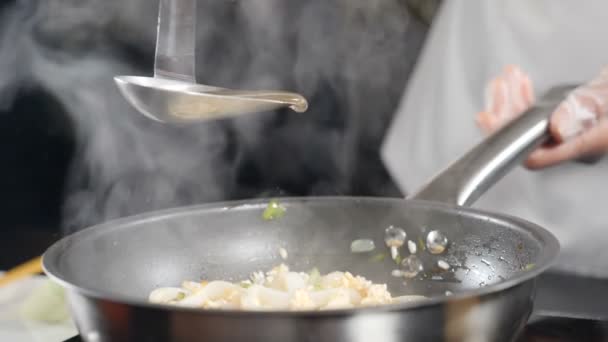 Matlagning läckra skaldjur risotto i stekpanna. Skjuten i slow motion. Fiskbuljong hälls ut ur sleven. Traditionell italiensk mat. Fullständig hd — Stockvideo