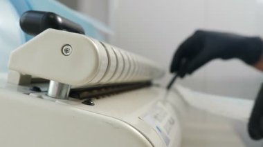 Diş kliniğinde sterilizasyon, bakteriyel arıtma ve dezenfeksiyon. İşlem için otoklava koymadan önce hemşireler özel el işi kağıt torbalara ekipman koyuyorlar. 4k video