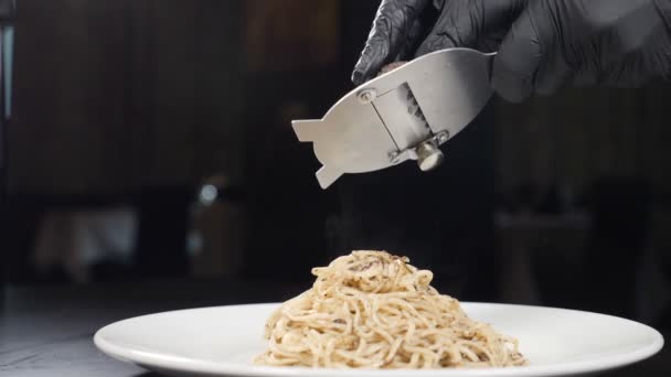 Kuchař strouhá černý lanýž na těstovinách v italské restauraci. Zpomal. Koncept gurmánské kuchyně, lanýže, italské těstoviny, výborná jídla. Lahodný italský fettuccine s černým lanýžem navrchu. Full hd
