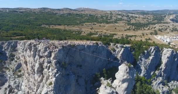 Drone schot vliegen dicht bij een enorme rots klif. Luchtfoto uitzicht op de Krim landschap met kliffen en bergen. Steile klif gezicht en berglijn. Grote klif omgeven door bos. 4 k video — Stockvideo