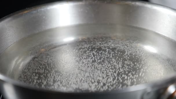 Water kokend in steelpan, Bubbels uit kokend water. macro shot van kleine en grote luchtbellen in water stijgt in slow motion. Warm water voor het koken van Italiaanse pasta in luxe restaurant. Vol hd — Stockvideo