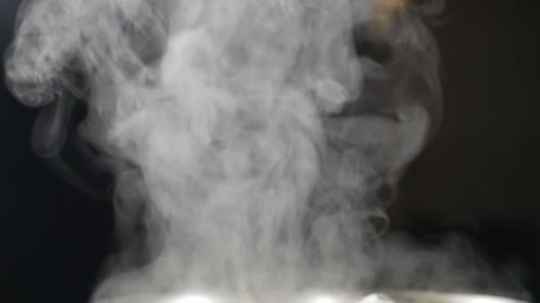 Brillant blanc vapeur se lève de Pan dans la cuisine tourné sur fond noir. Fumée, vapeur, brouillard nuages en mouvement isolés. La vapeur blanche monte sur la casserole. Au ralenti. Full hd — Video