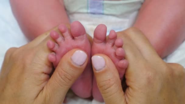 新生婴儿的小脚在妈妈手里。小孩的脚在父母的手里。快乐家庭的概念。童年，婴儿期，为人父母，为人母4k视频 — 图库视频影像