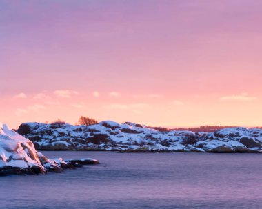 Gothenburg, İsveç'ın Batı kıyısı, kayalık ada üzerinde pembe günbatımı