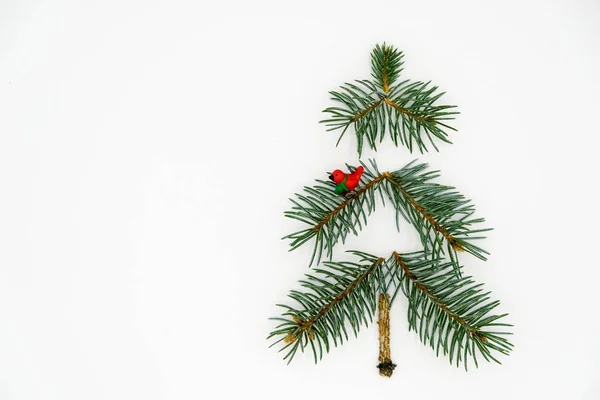 Noel ya da yeni yıl. Beyaz arka planda kırmızı kuşlu Noel ağacı. Minimalizm.