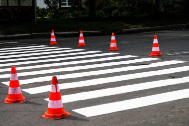 Küçük bir şehirde bir yol bakımı. Zebra geçitleri. Trafik konileri uyarıldı.