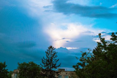 Doğa fenomeni. Bulutlar göz kırpan bir yüz gibi. Ukrayna'da küçük bir şehirde gün batımı. Kopyalama alanı.