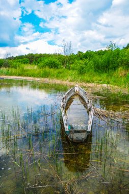 Bir orman arka planda saf bir göl Svitiaz sığ suda eski bir balıkçı teknesi. Yaz aylarında güneşli bir gün. Ukraynalı doğa.