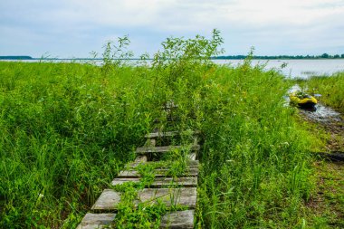 Ukrayna'da Lubyaz Gölü bataklık kıyısında El Sanatları ahşap köprü. Su turizmi için Sarı Kayak.