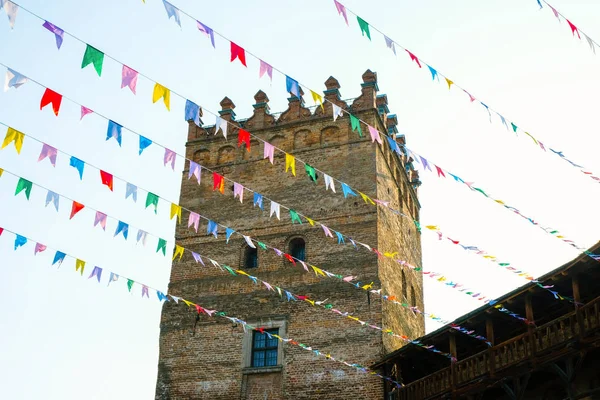 Birçok renkli bayraklar kale kulesinin arka planda rüzgarda çırpınıyor. Ukrayna'da Lutsk antik kale tatil dekorasyon.