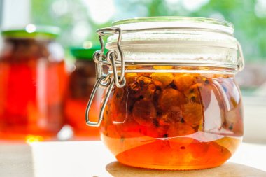 Güneş ışığında izole cam bir kavanozda ev yapımı bektaşi üzümü reçeli. Yakın çekim.