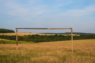 Orman ve sarı alanların arka plan üzerinde ahşap futbol kapısı. Ukrayna'da Sonbahar.
