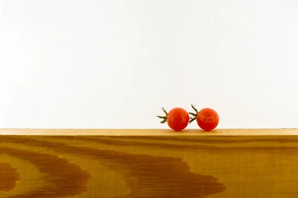 Dois Tomates Passa Corinto Uma Superfície Madeira Contexto Branco Minimalismo — Fotografia de Stock