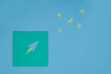  Mentollü yüzeyde mavi bir kağıt roketin silueti. Uzayı kopyala Boşluk kavramı.