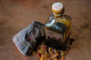 Üzüm sirkesiyle kare bir şişe mantarı. Kuru üzüm ve taş şişesinin yanındaki bakır yüzeyde. Üst Manzara. Boşluğu kopyala.