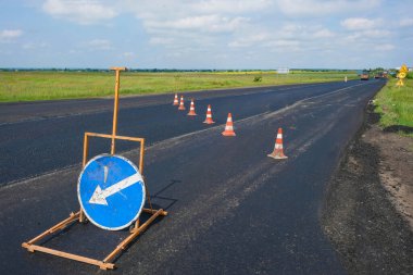 Ukrayna 'da yol onarımı. Yeni asfaltta yol konileri ve yol işaretleri var. Boşluğu kopyala.
