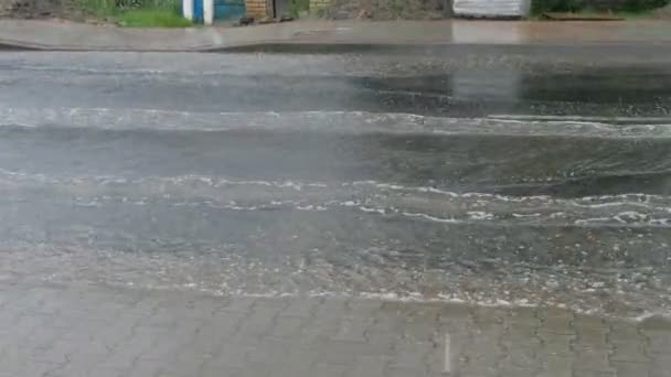 雷雨の後に歩道と道路の断片 水流を切断する車の車輪 — ストック動画