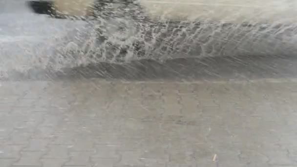 雷雨の間の道路上の水の流れと水の塵 車の水の流れを切断するホイール 歩道の水が噴き出す — ストック動画