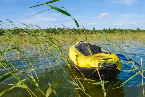 Yellow inflatable kayak with a blue paddle on Lake Svityaz in Ukraine.