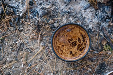  Kalın kahve köpüklü üst manzara. Görünür kabarcıklar ve doku. Ocakta kahve demliyorum. Orman toprak arka planı.