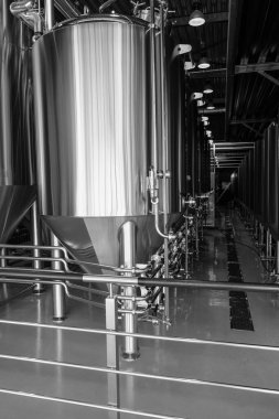 Bira fabrikasında bira demleme ekipmanı. Metal tanklar. Siyah ve beyaz resim.