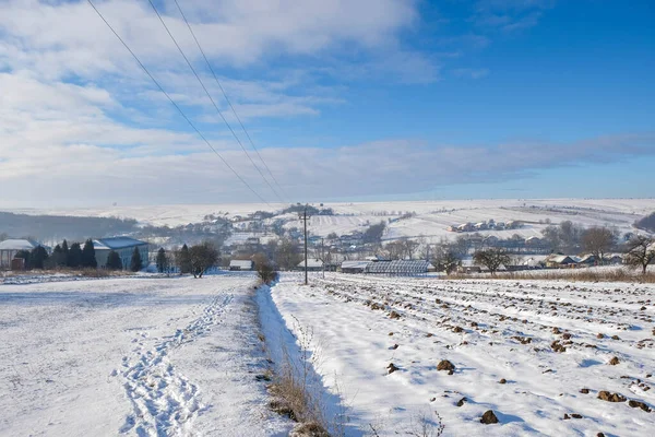 Ukrainian rural landscape with snow on a sunny winter morning. Solar panels in winter. Copy space.