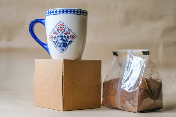 Hermetic packaging of ground coffee and a dutch cup cobalt blue. Mass production cup. Copy space.