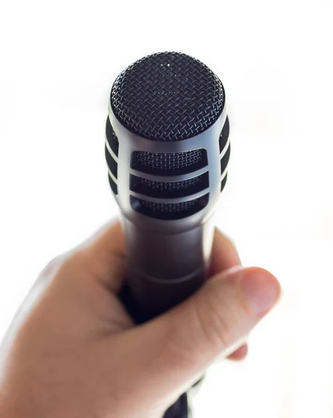 Гладкий Черный Микрофон Подставке Перед Открытым Белым Пространством Рука Белого — стоковое фото