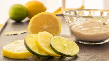 Taze limon ve kireç dilimleri önünde bütün ve dilimlenmiş meyve taze limonata yapmak için şeker küçük bir kase ile ayarlanır.