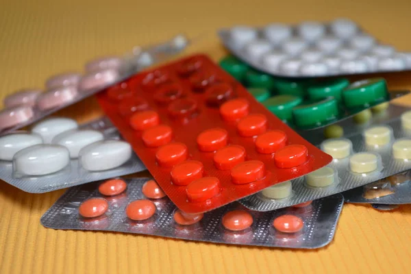 Sarı, beyaz, kırmızı, yeşil tıbbi haplar paketlenmiş, tabletler kabarcıklara doldurulmuş. Sağlık ve Tıp Konsepti — Stok fotoğraf
