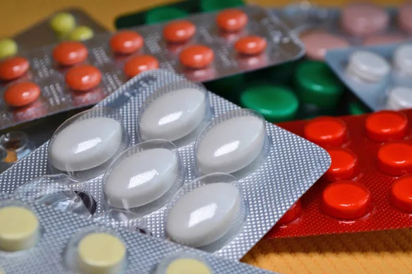 Sarı, beyaz, kırmızı, yeşil yuvarlak ve oval tıbbi tablet paketinde, kabarcıklar makroda Paketli tablet — Stok fotoğraf