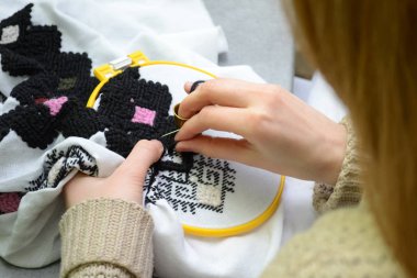 Kadın el nakışı ile siyah ve pembe yün iplik içinde görünüm yaptı hoop, beyaz kumaş üzerine embroiders