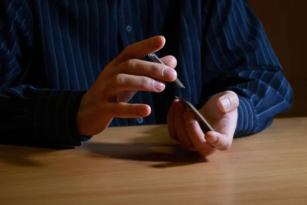 Man in darkness holding a set of playing cards and shuffle them, business strategic, competition concept