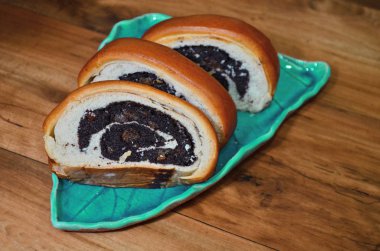 Haşhaş tohumu closeup bir ahşap yüzeyde bir yaprak şeklinde mavi tabakta yalan ile kırmızı taze topuz dilimlenmiş