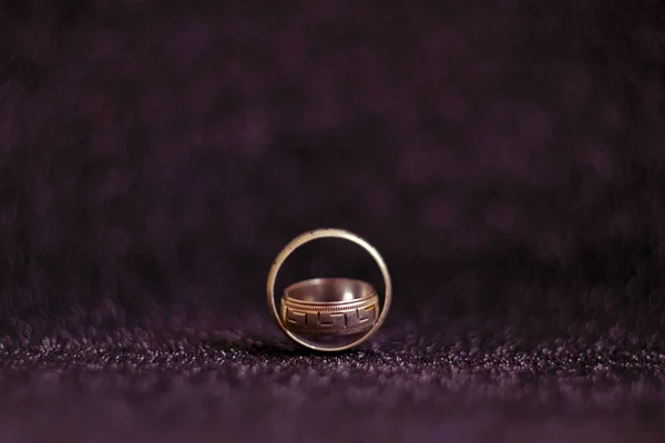 Two silver vintage wedding rings on a black shiny surface, with a blurred background and space for text