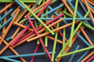 Çok renkli Hint tütsü sopa yalan rastgele üzerine koyu gri arka plan, geometrik kompozisyon