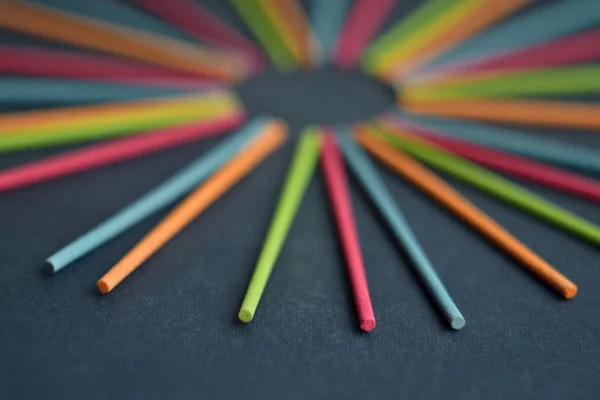 Güneş ve ışınları bir koyu gri arka plan üzerinde boşaltmak için boş daire şeklinde çok renkli Hint tütsü sopa yalan
