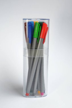 Çok renkli kalemler kapalı şeffaf cam, yan görünüm boşaltmak gölge beyaz zemin üzerine ayakta kümesi