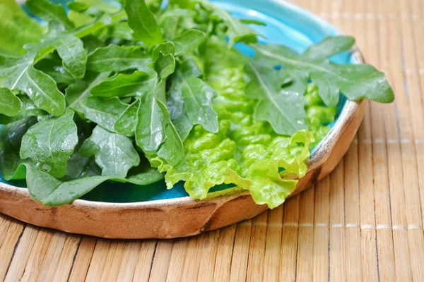 Summer mix of vegetables salad arugula spinach in blue plate on wooden surface — Stock Photo, Image